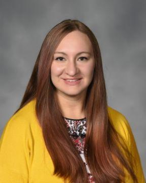 Woman smiling, looking at camera.